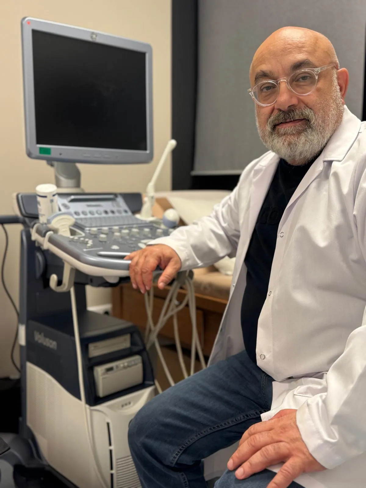 Op. Dr. Salim Korucu muayenehane ortamında ultrason cihazı yanında